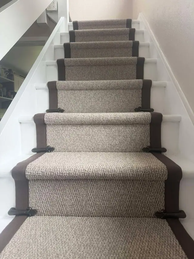 Grey runner with dark binding and stair rods
