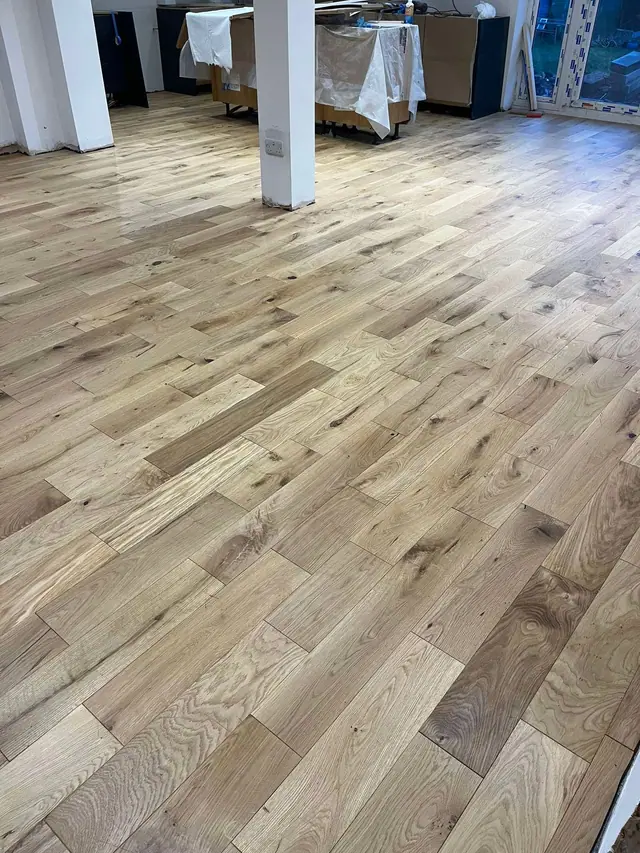 Pale real wood planks across an open kitchen