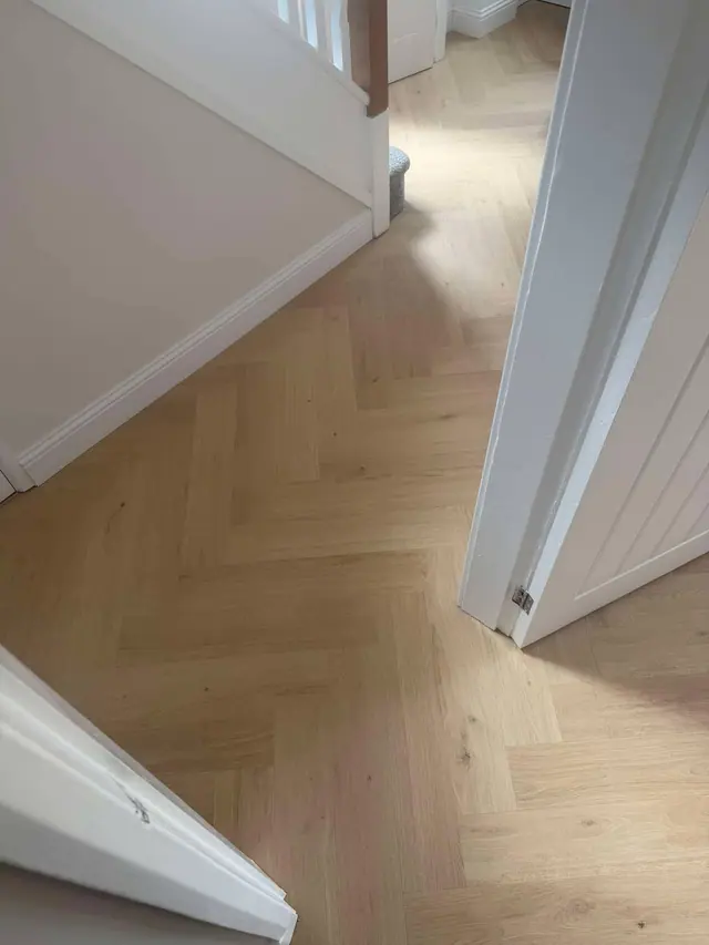 Light herringbone laminate through a hallway