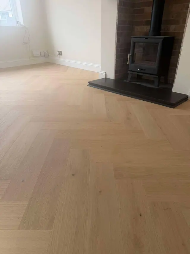 Pale herringbone laminate beside a fireplace