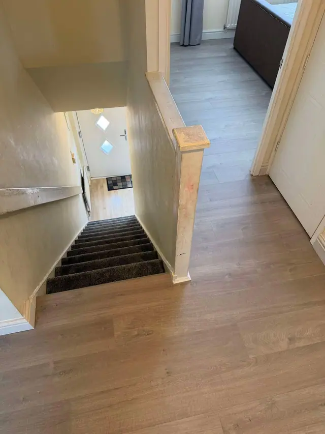 Laminate on a landing beside carpeted stairs