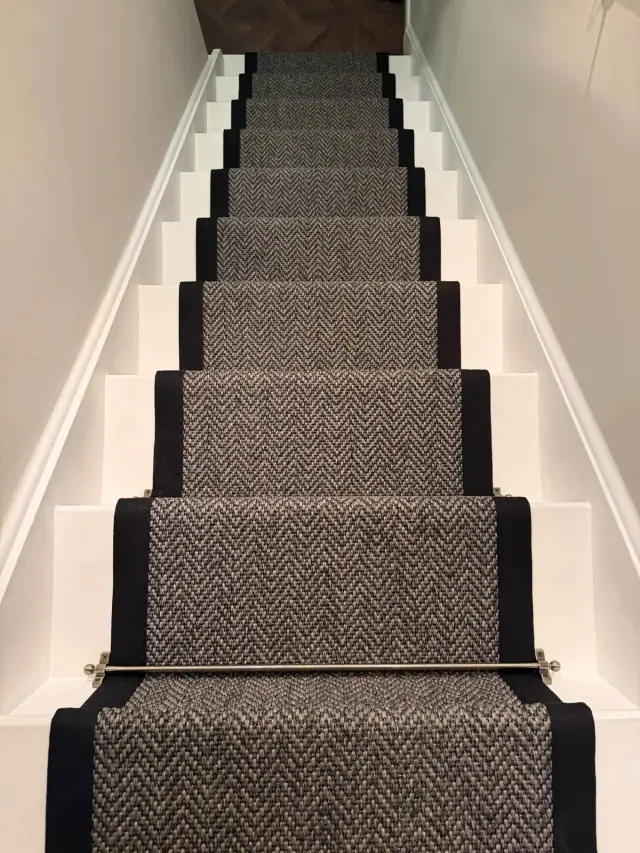 A patterned runner on white stairs